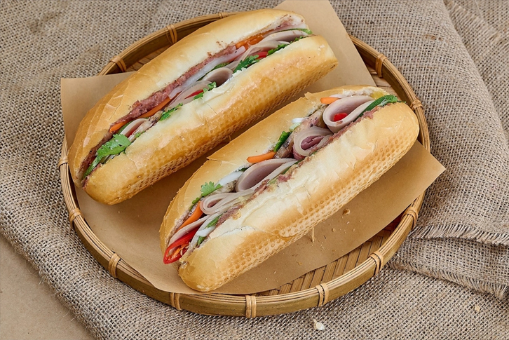 Bánh mì Việt Nam với pate, thịt nguội và rau thơm được bày bán trên phố